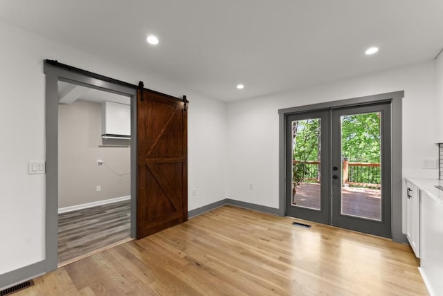 interior space featuring light wood-style floors, french doors, and visible vents