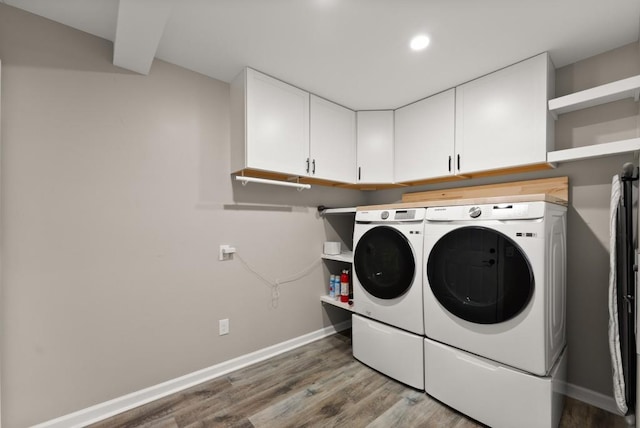 laundry area featuring washing machine and clothes dryer, cabinet space, baseboards, light wood finished floors, and recessed lighting