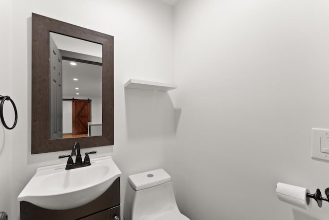 bathroom with toilet, recessed lighting, and vanity