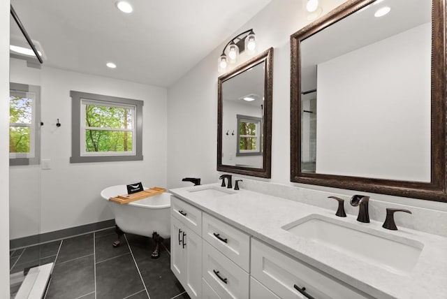 full bathroom with a sink, a freestanding tub, recessed lighting, and tile patterned floors