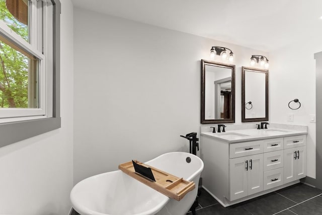 bathroom with double vanity, tile patterned floors, a freestanding bath, and a sink