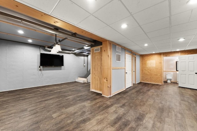 finished below grade area featuring recessed lighting, dark wood-style floors, and visible vents