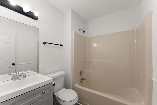 full bathroom featuring toilet, a textured ceiling, bathing tub / shower combination, and vanity