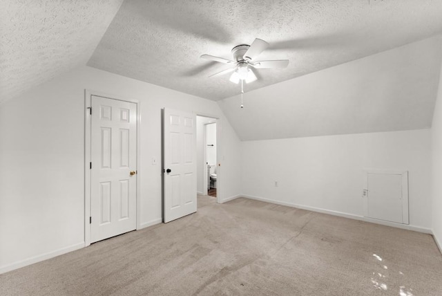 additional living space with ceiling fan, light colored carpet, and lofted ceiling