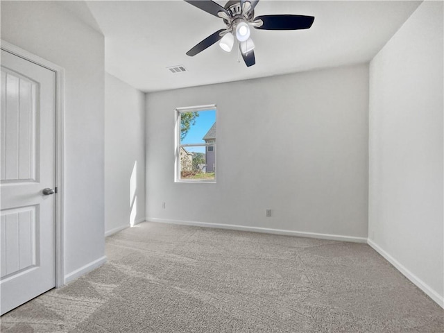 spare room featuring light colored carpet and ceiling fan