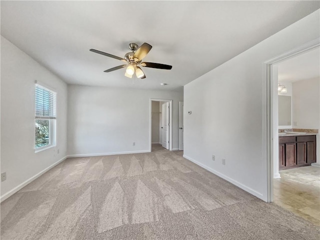 spare room with ceiling fan and light carpet