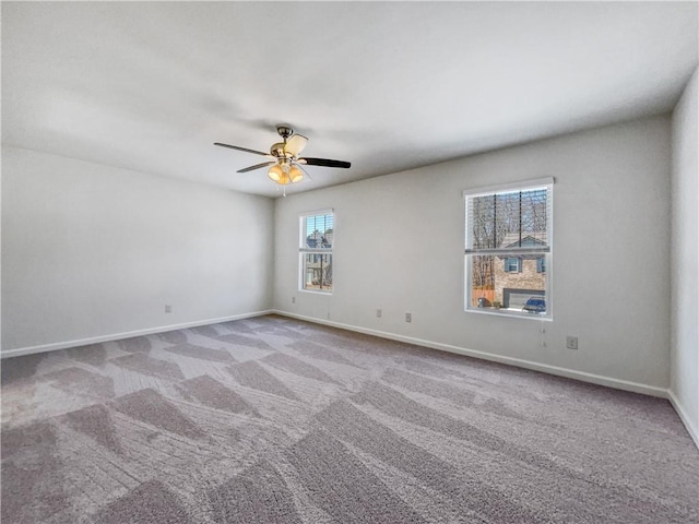 carpeted spare room with ceiling fan and plenty of natural light