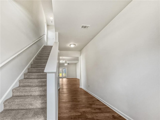 stairway featuring wood-type flooring and ceiling fan