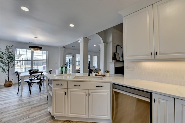 kitchen featuring ornate columns, dishwasher, light stone countertops, and white cabinets