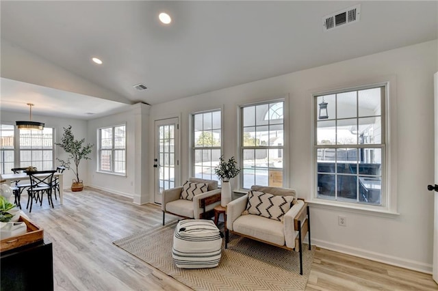 living area featuring vaulted ceiling and light wood-type flooring