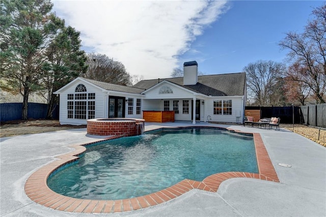 view of pool with a patio area, french doors, and an in ground hot tub