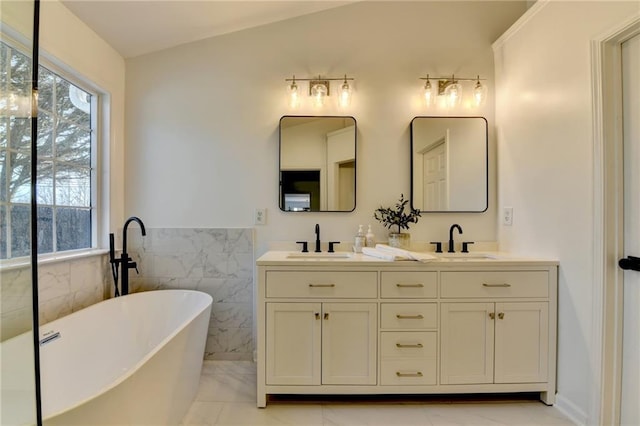 bathroom with vanity, a bathtub, and tile walls