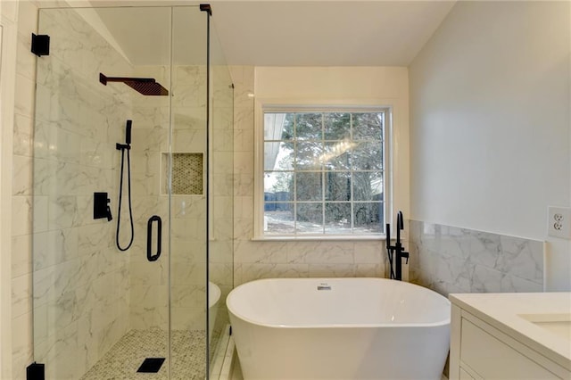 bathroom featuring vanity, plus walk in shower, and tile walls