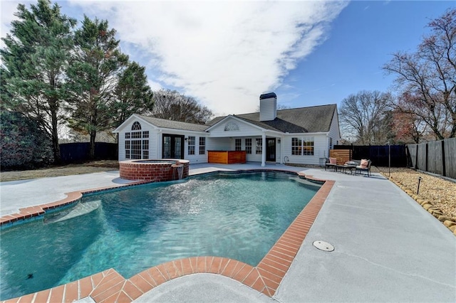 view of pool featuring an in ground hot tub, an outbuilding, and a patio area