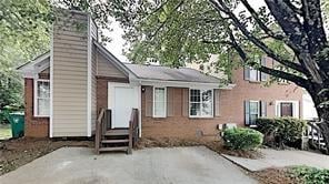 view of front of home featuring entry steps, a patio, and a chimney