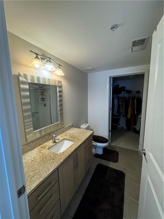 bathroom featuring tile patterned flooring, vanity, and toilet