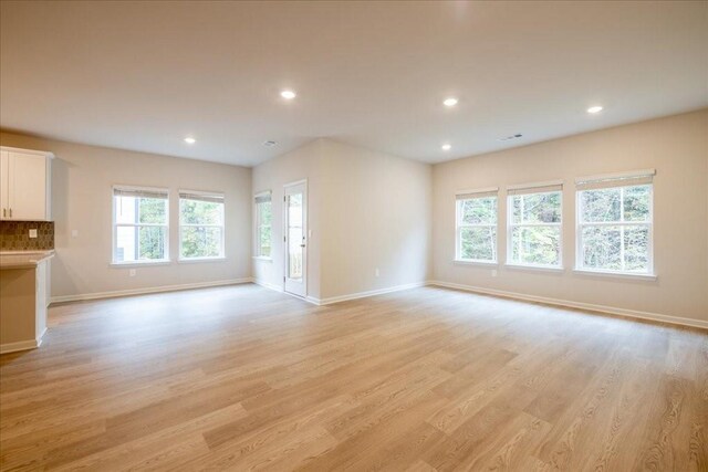 unfurnished living room featuring light hardwood / wood-style floors and a wealth of natural light