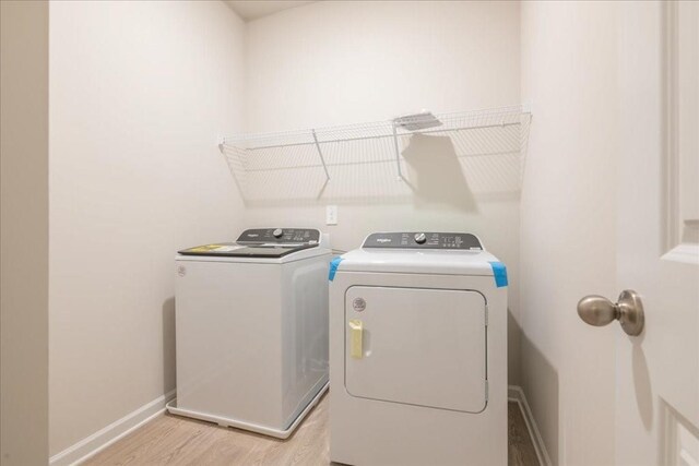 laundry room featuring washer and dryer and light wood-type flooring