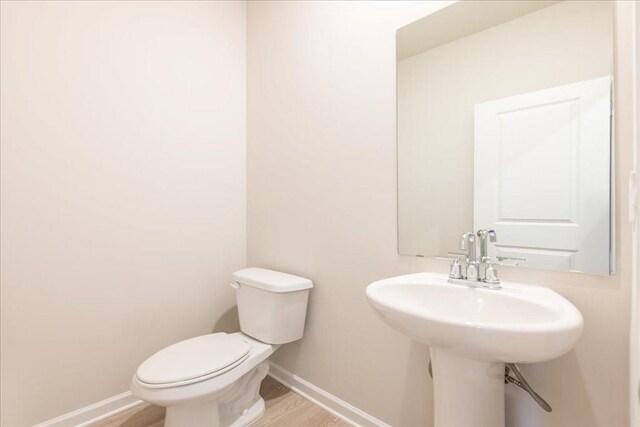 bathroom featuring hardwood / wood-style floors and toilet