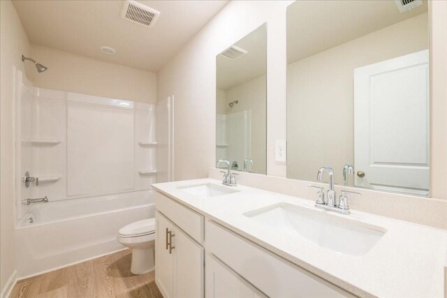 full bathroom with hardwood / wood-style flooring, vanity, toilet, and tub / shower combination