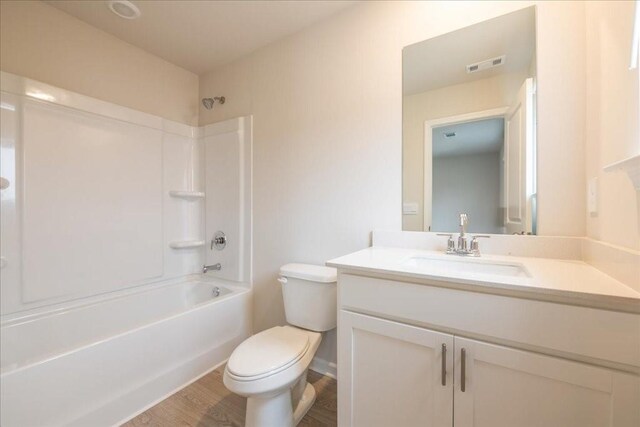 full bathroom featuring hardwood / wood-style floors, vanity, toilet, and shower / bathtub combination