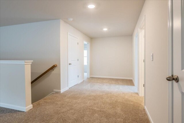 hall featuring light colored carpet