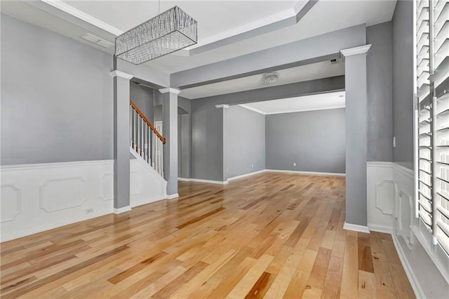 interior space featuring an inviting chandelier, wood-type flooring, and ornamental molding