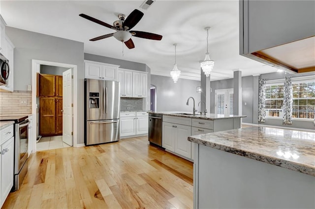 kitchen featuring white cabinetry, sink, appliances with stainless steel finishes, and tasteful backsplash