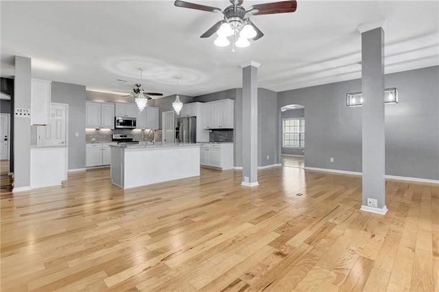 unfurnished living room with light hardwood / wood-style flooring, ceiling fan, and sink