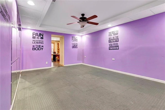 carpeted empty room featuring a tray ceiling and ceiling fan