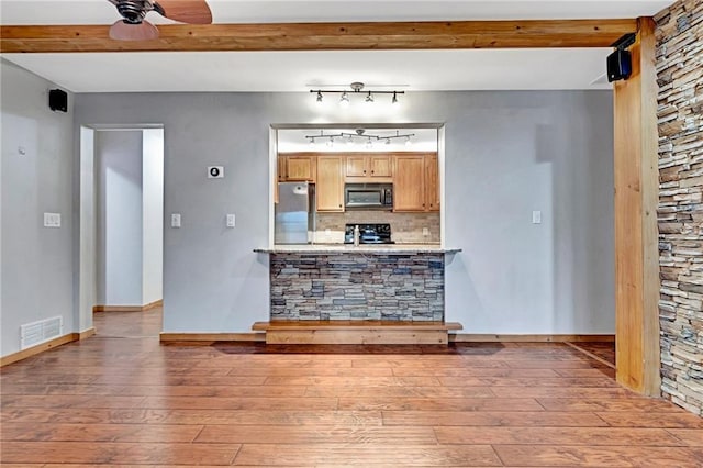 interior space featuring tasteful backsplash, hardwood / wood-style flooring, ceiling fan, and black appliances