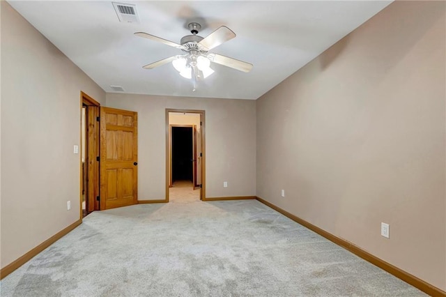 unfurnished bedroom with ceiling fan, a walk in closet, and light carpet