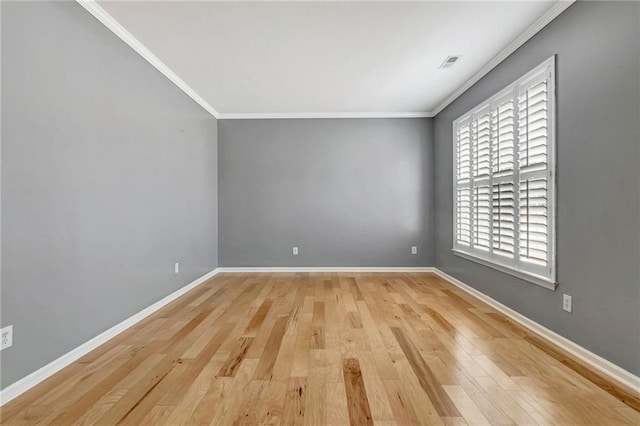 spare room featuring ornamental molding and light wood-type flooring