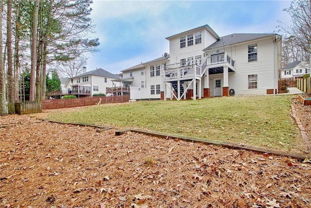 rear view of property with a lawn and a deck