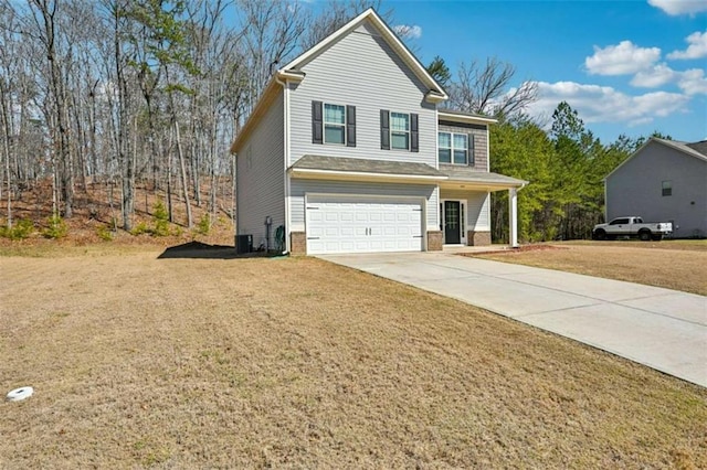 traditional-style home featuring a front lawn, concrete driveway, and a garage