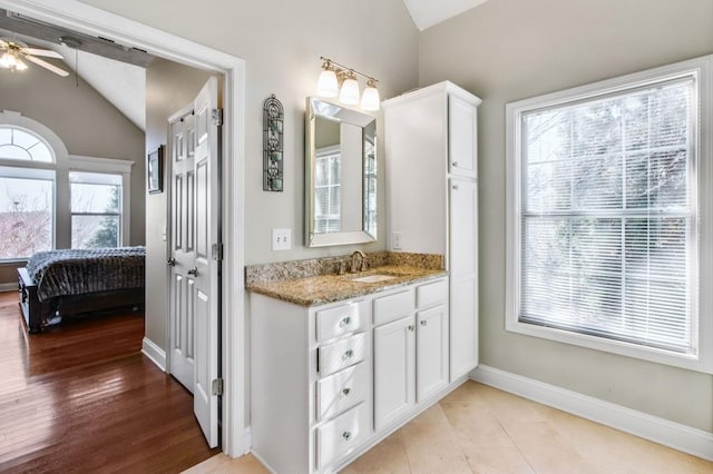 bathroom featuring ceiling fan, vanity, wood-type flooring, and vaulted ceiling