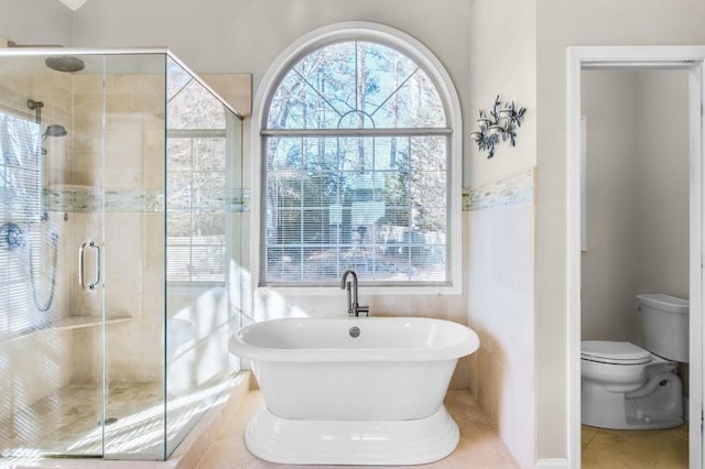 bathroom featuring separate shower and tub, tile patterned flooring, and toilet