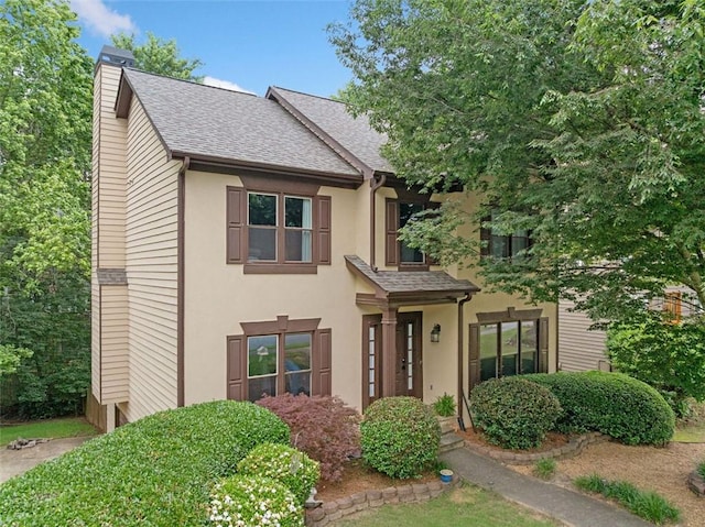 404 Pine Grove Way, Woodstock, GA 30189 - view of front facade featuring roof with shingles, a chimney, and stucco siding