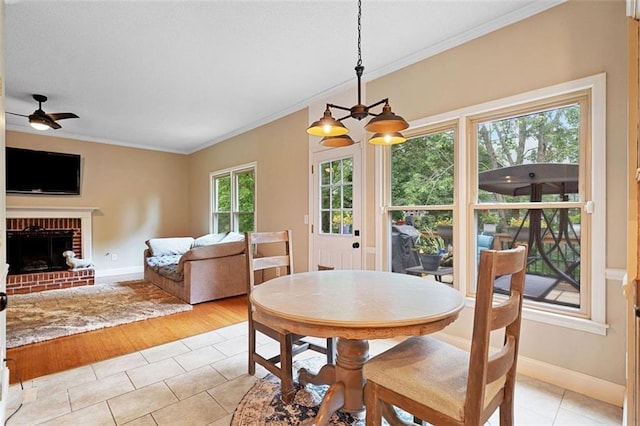 404 Pine Grove Way, Woodstock, GA 30189 - dining area with ornamental molding, light tile patterned flooring, baseboards, a ceiling fan, and a brick fireplace