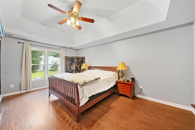 404 Pine Grove Way, Woodstock, GA 30189 - bedroom with a tray ceiling, baseboards, and wood finished floors