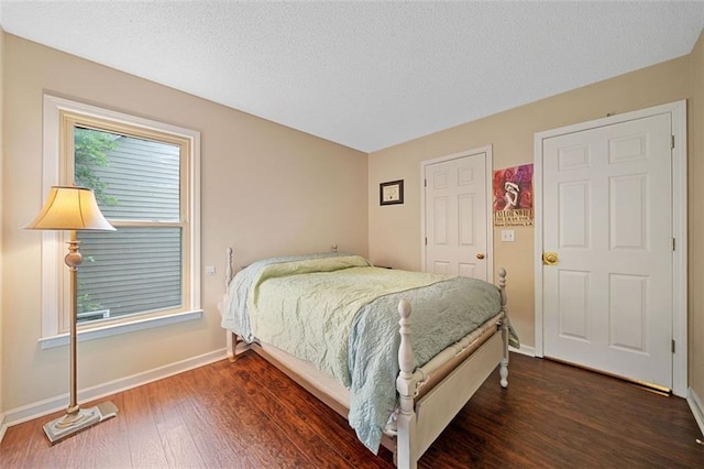 404 Pine Grove Way, Woodstock, GA 30189 - bedroom with dark wood finished floors, baseboards, and a textured ceiling