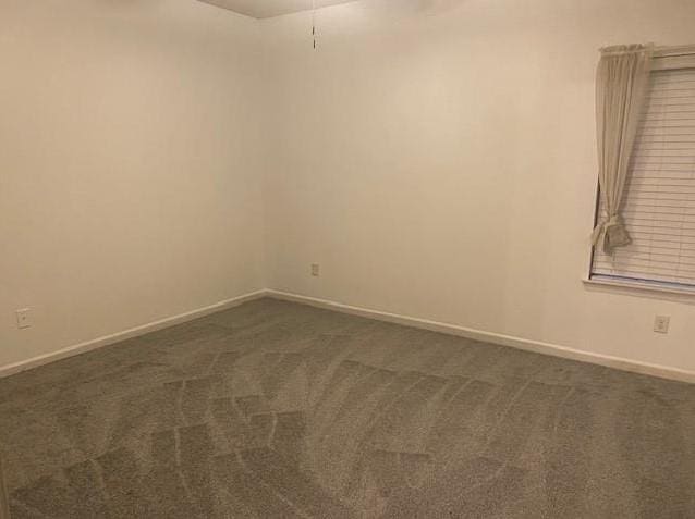 empty room featuring dark carpet