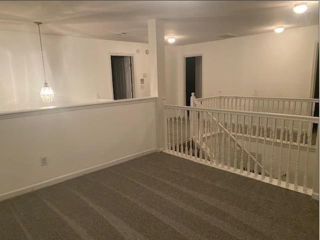 unfurnished room with dark carpet