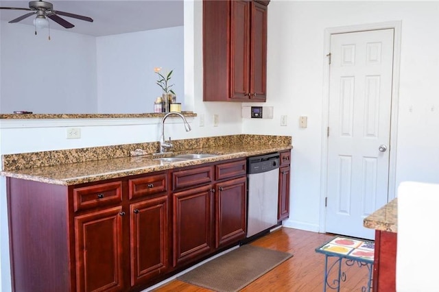 kitchen with light stone countertops, stainless steel dishwasher, sink, dark hardwood / wood-style flooring, and ceiling fan