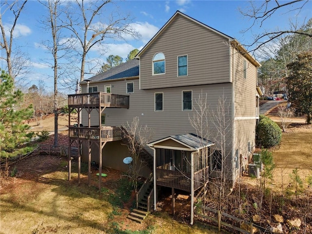 rear view of property with a sunroom and a deck