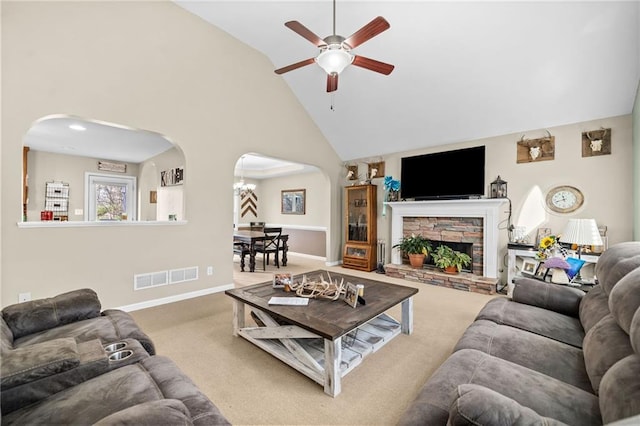 carpeted living room featuring a fireplace, high vaulted ceiling, and ceiling fan