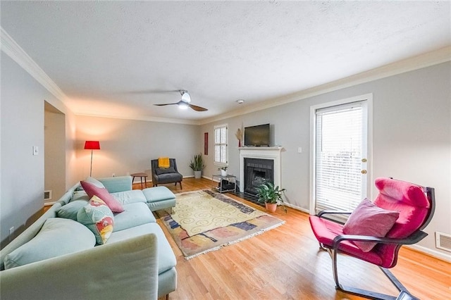 living area with a fireplace, wood finished floors, and a healthy amount of sunlight