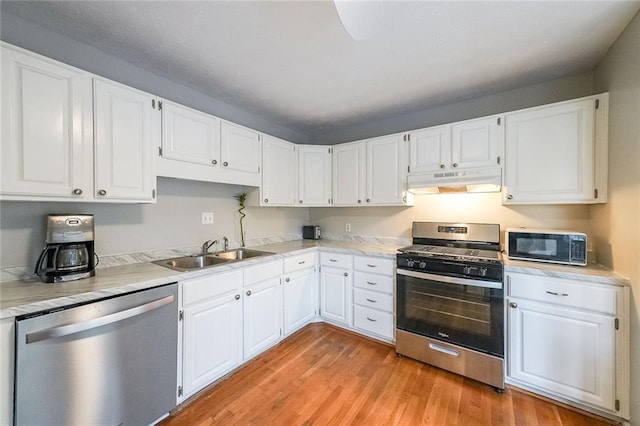 kitchen featuring a sink, appliances with stainless steel finishes, white cabinets, and under cabinet range hood