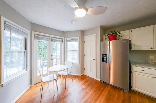 kitchen featuring a ceiling fan, baseboards, stainless steel fridge with ice dispenser, light wood-style floors, and french doors