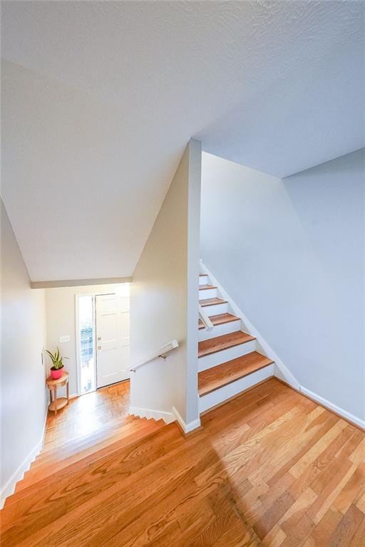 stairs featuring wood finished floors and baseboards